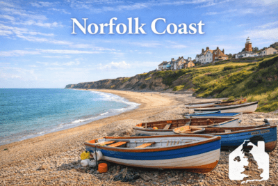 Norfolk Coast beach with fishing boats and lighthouse – popular UK holiday home location.