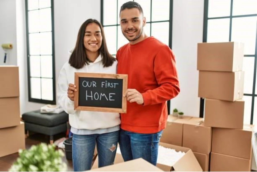 First-time buyer couple celebrating their first home purchase with a 100% mortgage in the UK