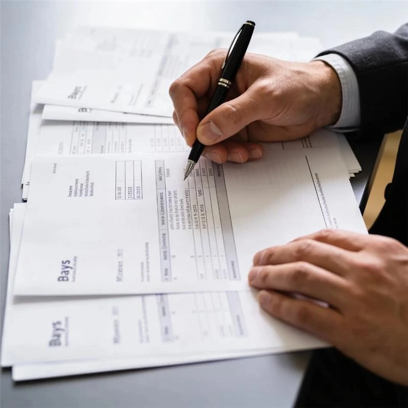 close up of hands reviewing income and payslip documents for UK mortgage assessment